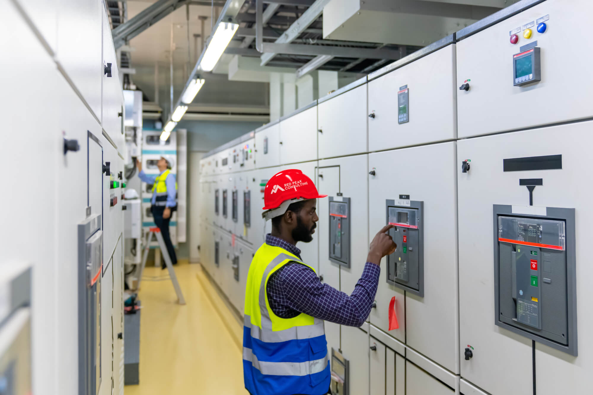 Worker wearing a hard hat operating industrial machinery.