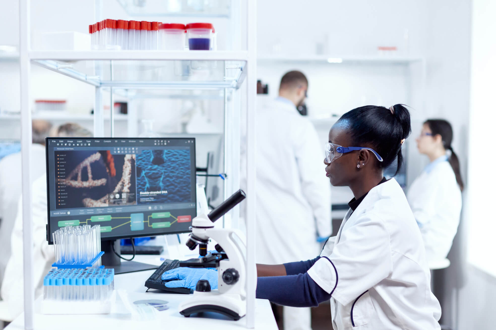 Scientist working at a microscope in a laboratory, performing scientific experiments.