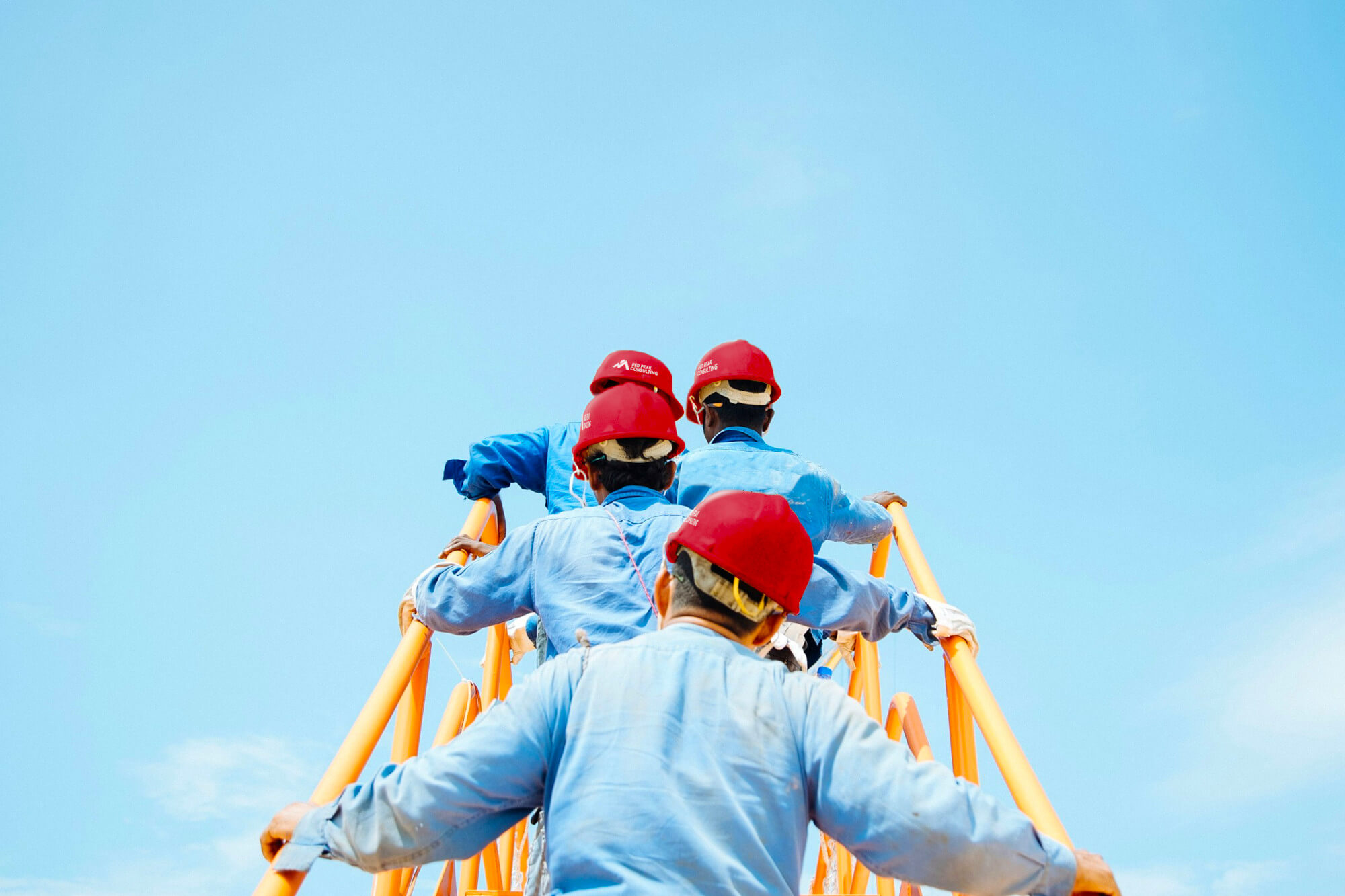 Construction workers climbing a metal staircase
