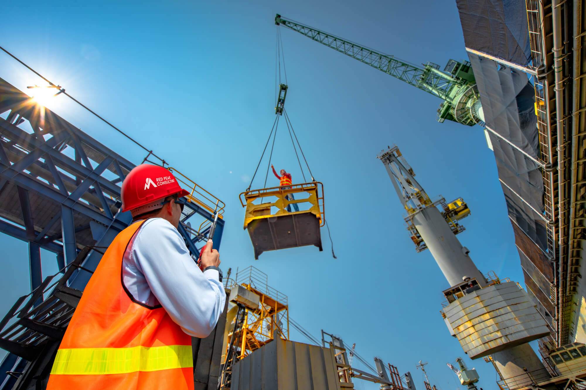 Two construction workers using a crane